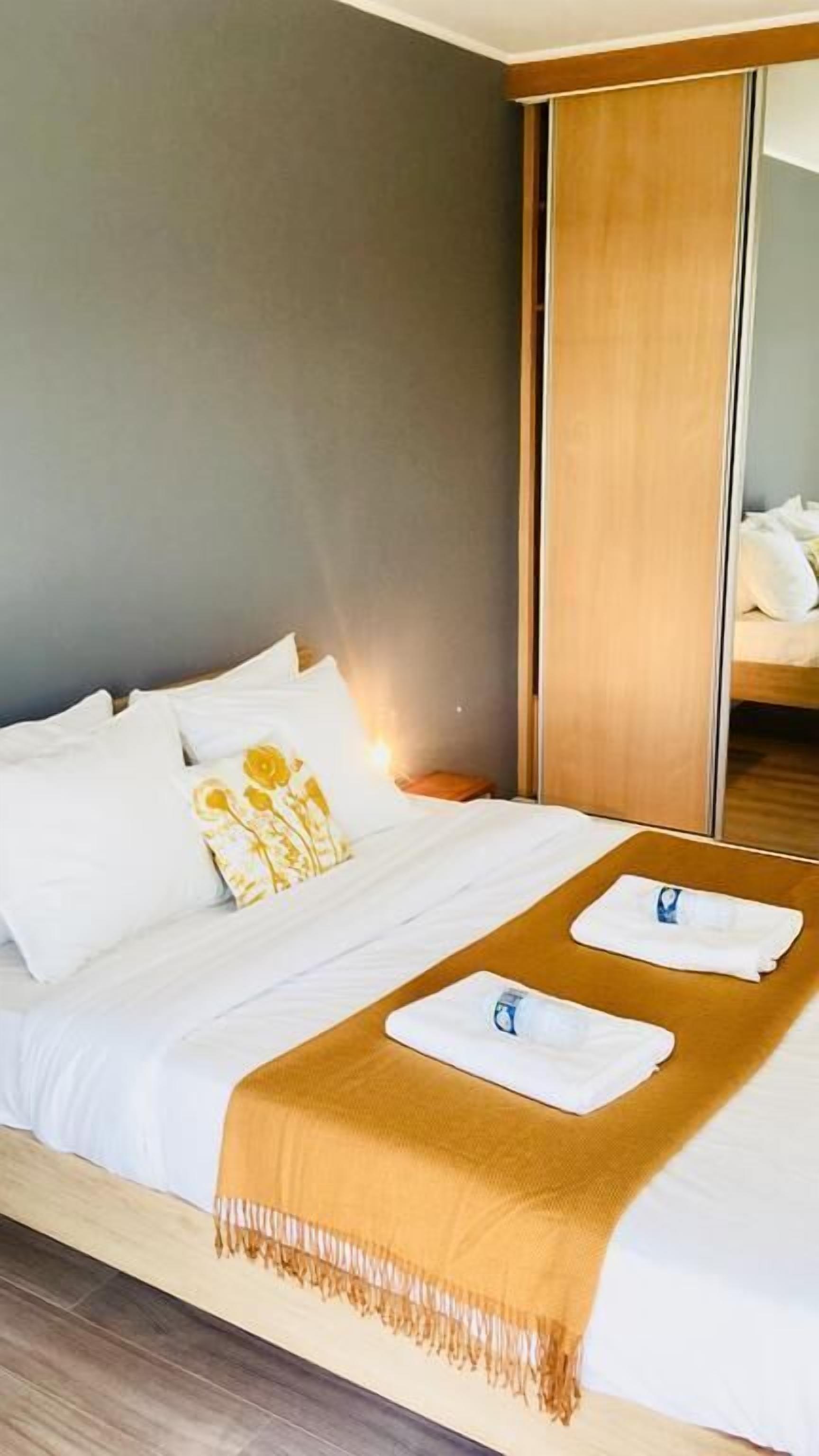 Une chambre d’hôtel avec un lit, une armoire en bois et un miroir.