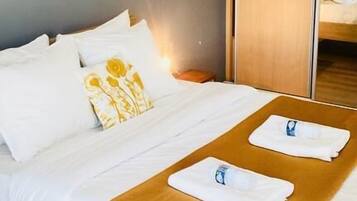 Une chambre d’hôtel avec un lit, une armoire en bois et un miroir.