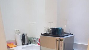 A compact kitchen with a microwave, a small refrigerator, and a sink. - Gorgeous Studio On Hilton Beach (Tel Aviv)