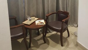 A small room with a table and two chairs, a lamp, and a curtain. - Gorgeous Studio On Hilton Beach (Tel Aviv)