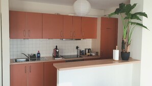 A kitchen with brown cabinets, a white tiled backsplash, and a wooden countertop.