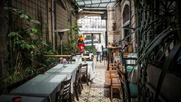 An indoor dining area with tables and chairs, a patterned floor, and a glass ceiling. - Large Beautiful Studio in Old Jaffa (Tel Aviv)