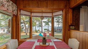 A dining area with a bay window overlooking a residential neighborhood and a body of water. - SUPERB VIEW BIG  SEBAGO LAKE WESTERN SIDE OF LAKE (Standish)