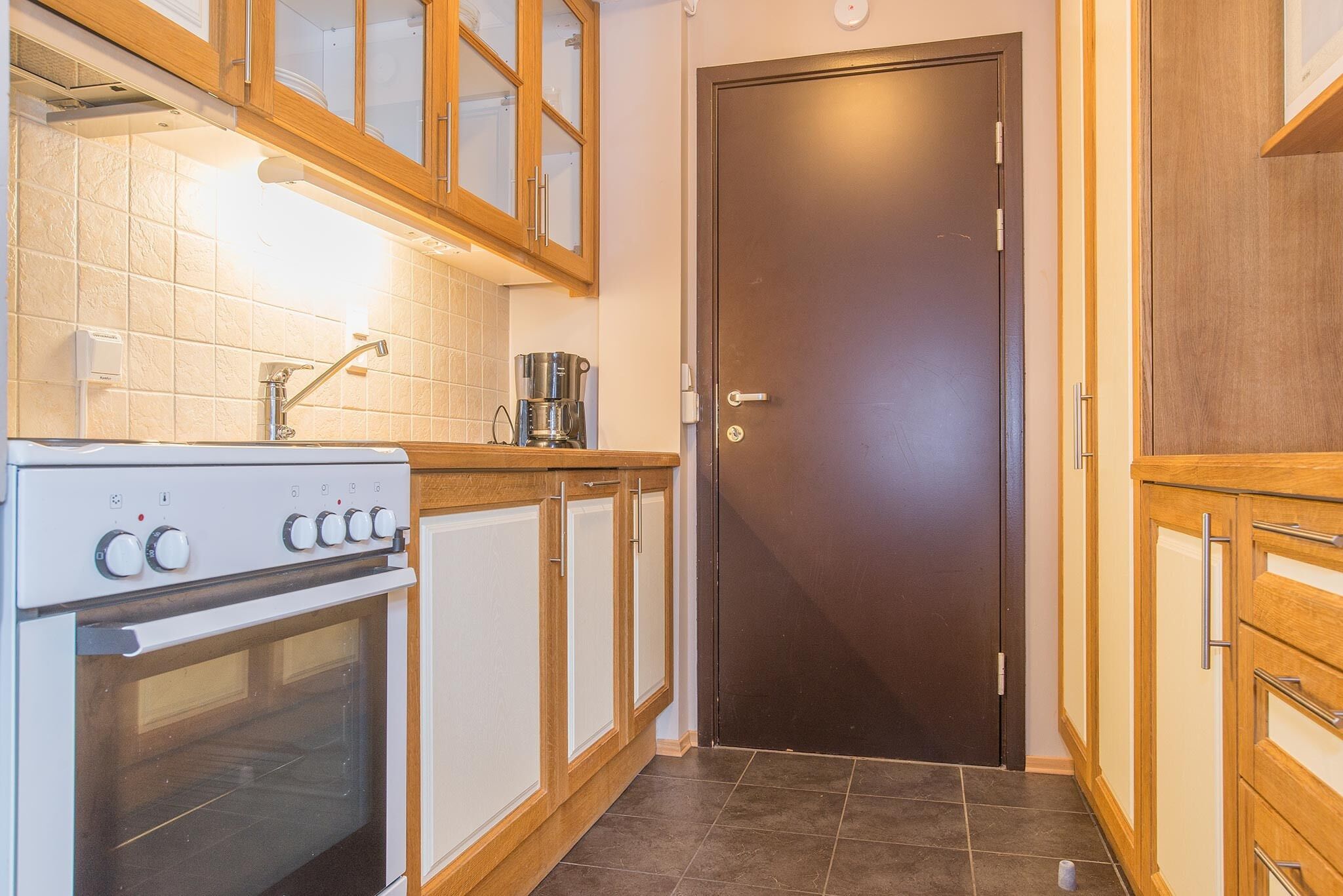 A kitchen with a stove, oven, and cabinets.