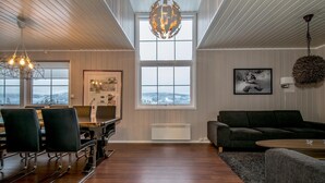 A modern living room with a dining area, large windows, and a view of the outdoors. - Trysilfjell Apartment Hotel (Trysil)