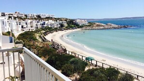 Ett hotell vid kusten med vita byggnader, en sandstrand och en klippig kustlinje.