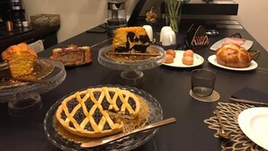 A dining table with various dishes, including pies and a fruit bowl, set for a meal. - Casa Vittoria Napoli - Santa Lucia (Naples)