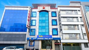 Un hôtel appelé «Jaggi Palace», doté d’une façade moderne, de grandes fenêtres et d’une enseigne bien visible.