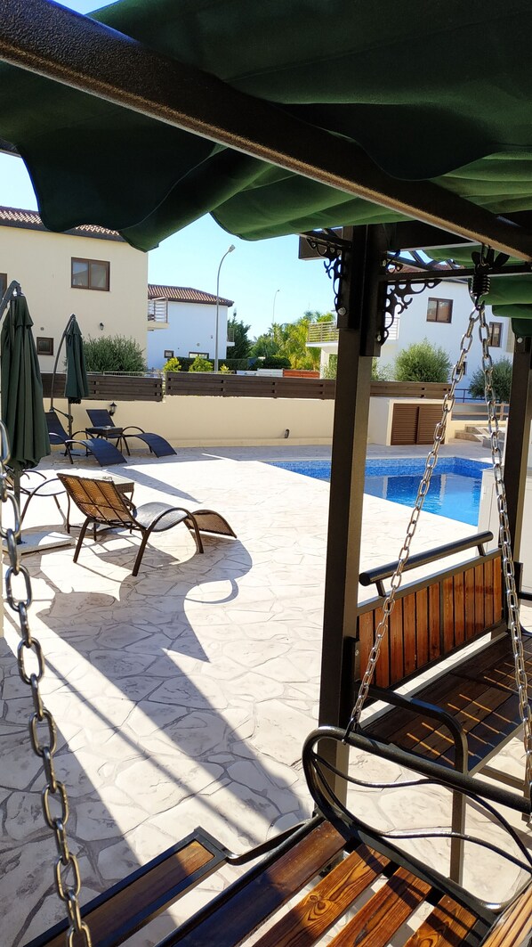 Alberca al aire libre, sombrillas en la alberca y camastros