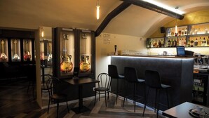 A bar area with a counter, chairs, and a display of guitars. - Golden Apartments (Kosice)
