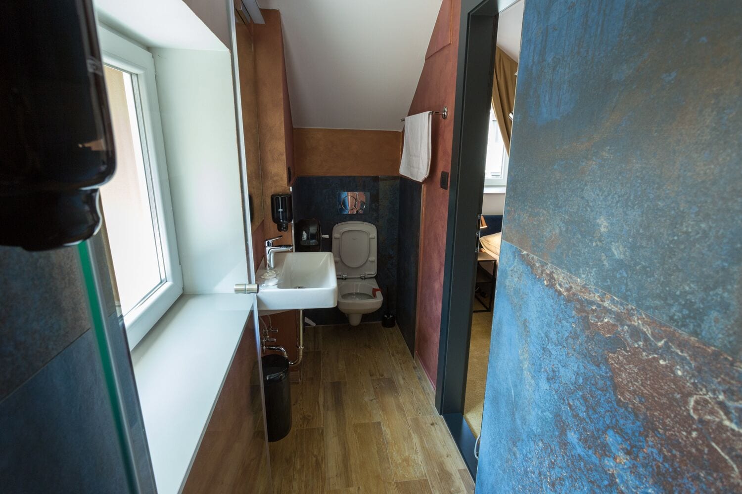 Baño pequeño con inodoro, lavamanos y secador de manos.