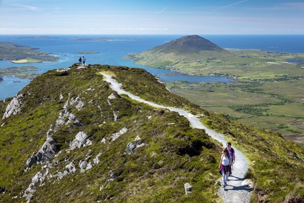A hiking trail on a grassy hill with a view of the sea and distant islands. - Galway's CastleHacket House King's Room (Belclare)