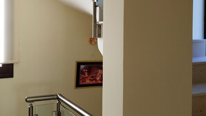 Una escalera moderna con barandillas de vidrio y pasamanos de metal, que conduce a un piso superior.