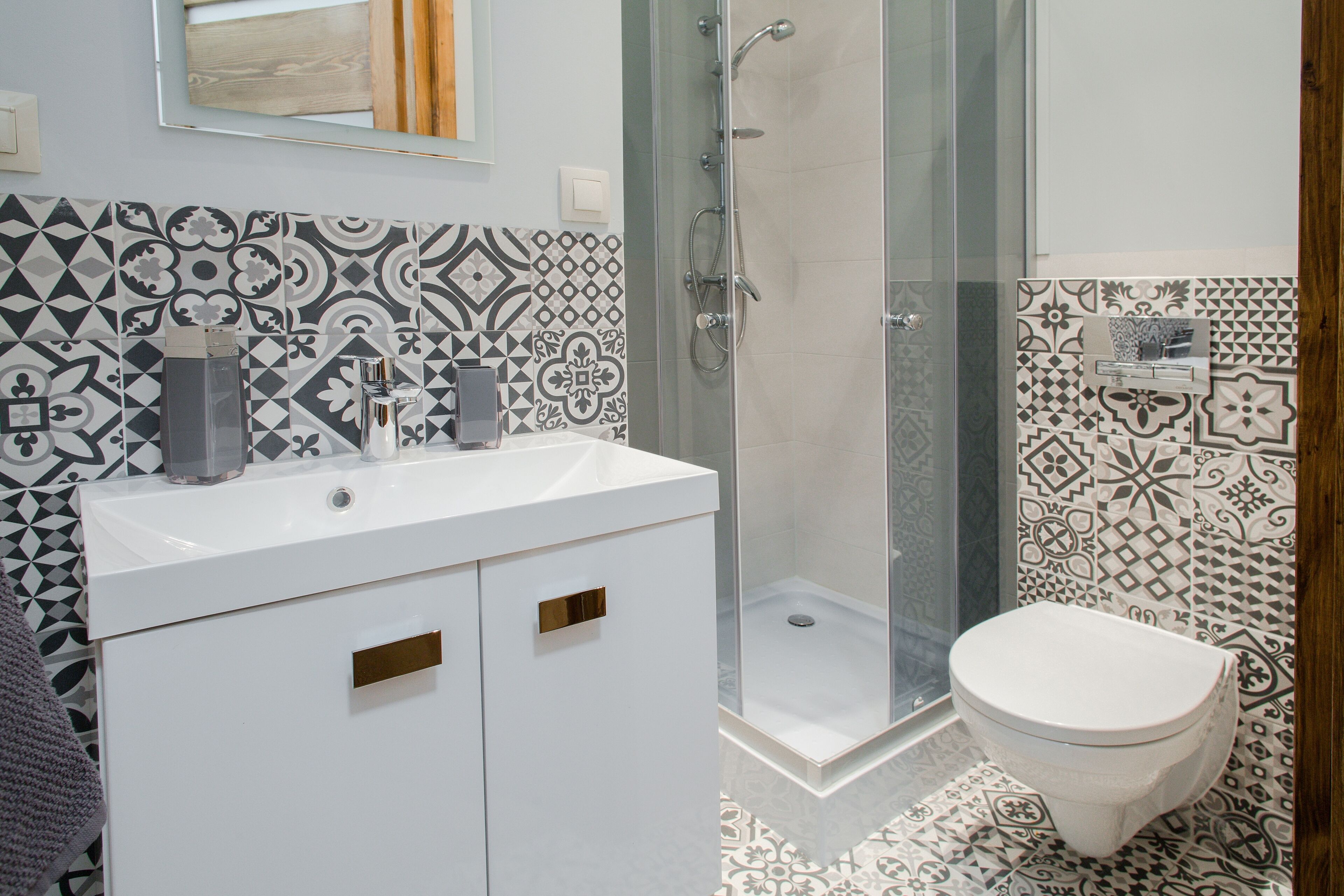 A bathroom with a white sink, a glass shower enclosure, and a toilet.