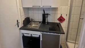 A compact kitchen with a sink, stove, and a coffee maker. - Holiday house in a quiet location and near the forest (Wernigerode)