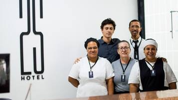 Um grupo de pessoas em um saguão de hotel com um logotipo grande na parede.