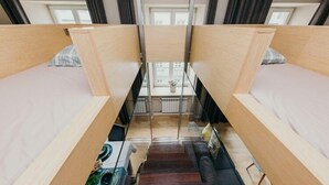 A modern loft-style room with two bunk beds, a staircase, and a dining area. - Apartment Cohen - Aleje Ujazdowskie (Warsaw)