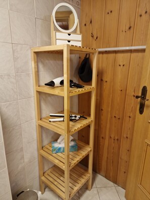 A wooden shelf with a mirror, hairdryer, and other toiletries. - Rosy's House Pension Privatzimmer (Bad Goisern)