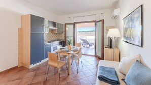 Un espace de vie compact comprenant une kitchenette, un coin repas et un balcon avec vue.