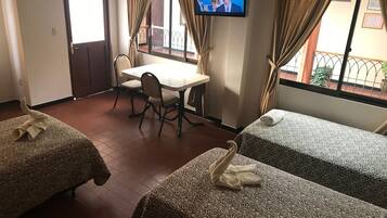 Classic Quadruple Room | Peralatan tempat tidur premium, peti besi dalam bilik, meja