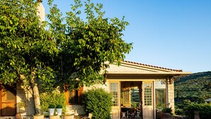 A building with a covered patio, outdoor seating, and a view of a hilly landscape. -  A Grand Estate, with 2 Pools, Gym & Tennis Court (Peza)