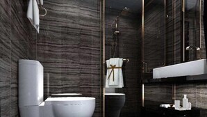 Une salle de bain moderne avec un mur en marbre, une douche en verre, des toilettes blanches et un meuble-lavabo avec un miroir.