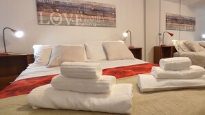 Ein Hotelzimmer mit einem Bett, zwei Nachttischen, zwei Lampen und einer Wand mit einem 'LOVE FAMILY' Schild.
