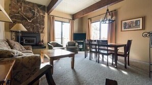 A cozy living room with a fireplace, comfortable seating, and a dining area. - CB311 | Epic Views | Outdoor Pool and Hot Tub | Ski In/Out (Steamboat Springs)
