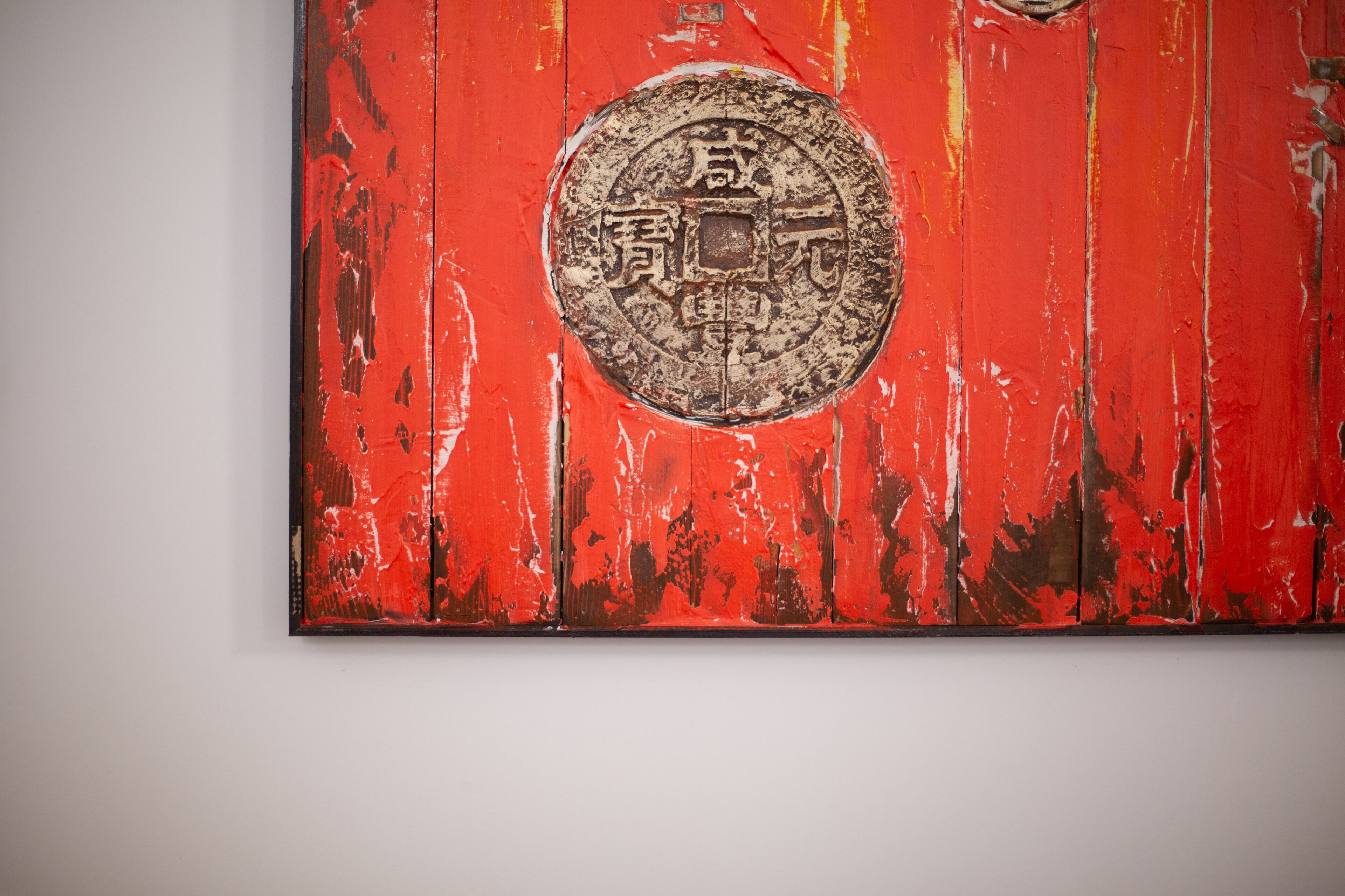 A red wooden panel with a circular emblem.