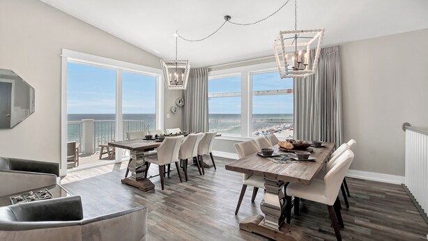 A spacious dining area with a view of the ocean, a large window, and a chandelier.