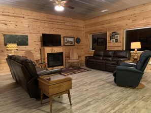A cozy log cabin interior with a fireplace, leather furniture, and a television. - Breathtaking views and an absolute hiking paradise!!! (Goreville)