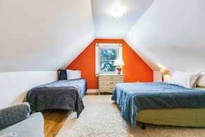 Une chambre avec deux lits, une fenêtre donnant sur un beau paysage et un luminaire au plafond.