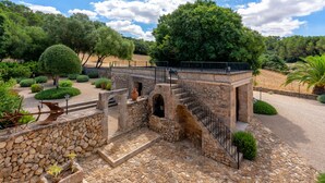 A stone bridge with a metal railing, surrounded by well-maintained gardens and trees. - QUIET RURAL HOUSE (San Juan)
