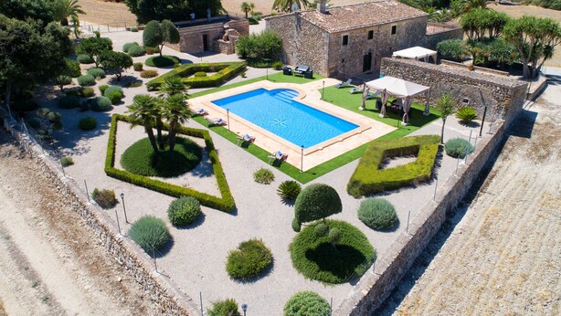 A pool surrounded by geometric garden beds, a stone building, and a view of the countryside. - QUIET RURAL HOUSE (San Juan)