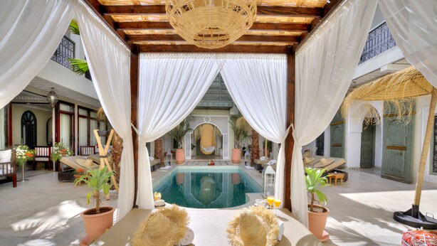 A luxurious pool area with a clear view of the pool, surrounded by white drapes and potted plants. - Riad Sokera Hotel & Spa - Adults Only (Marrakech)