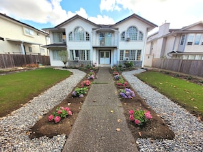Stunning two-story home with a central entrance and beautifully manicured lawn.