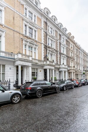A row of classic terraced houses with a wet pavement, likely after rain. - Bright stylish Nott Hill apart sleeps 6 (London)