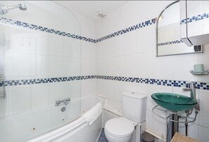 A bathroom with a bathtub, toilet, and green sink. - Bright stylish Nott Hill apart sleeps 6 (London)