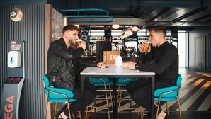Two people sitting at a table in a modern cafe with a hand sanitizer station nearby. - YOTEL Glasgow (Glasgow)