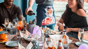 Una mesa de comedor con diferentes platos, vasos y botellas, evocando un ambiente de restaurante.