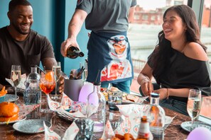 Una mesa de comedor con diferentes platos, vasos y botellas, evocando un ambiente de restaurante.