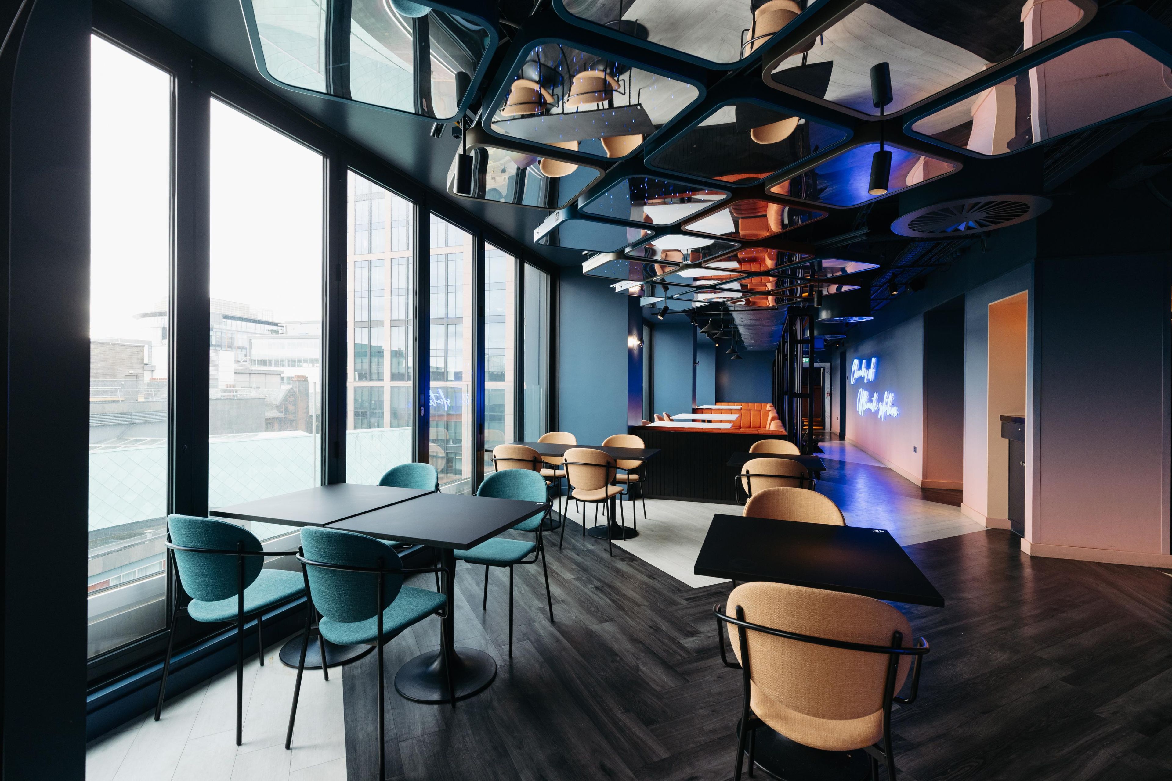 A modern interior with large windows, a bar area, and seating arrangements.