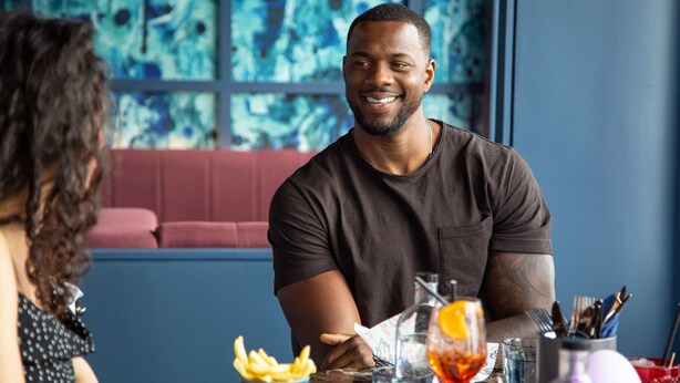 A person seated at a table with a drink, a plate of fries, and a menu. - YOTEL Glasgow (Glasgow)