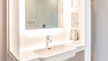 A modern bathroom with a large mirror, a sink, and a towel rack.