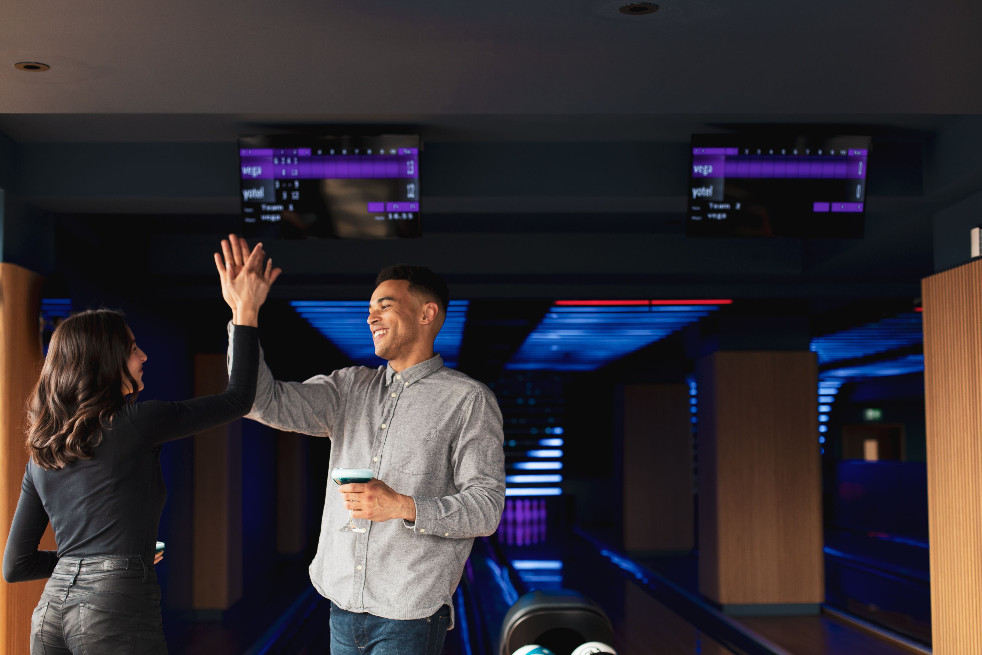 Una bolera con múltiples pistas, marcadores electrónicos sobre la pista y un diseño de interiores moderno.