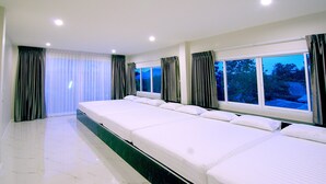 Habitación de hotel con una cama grande, una ventana con cortinas y vistas al exterior.