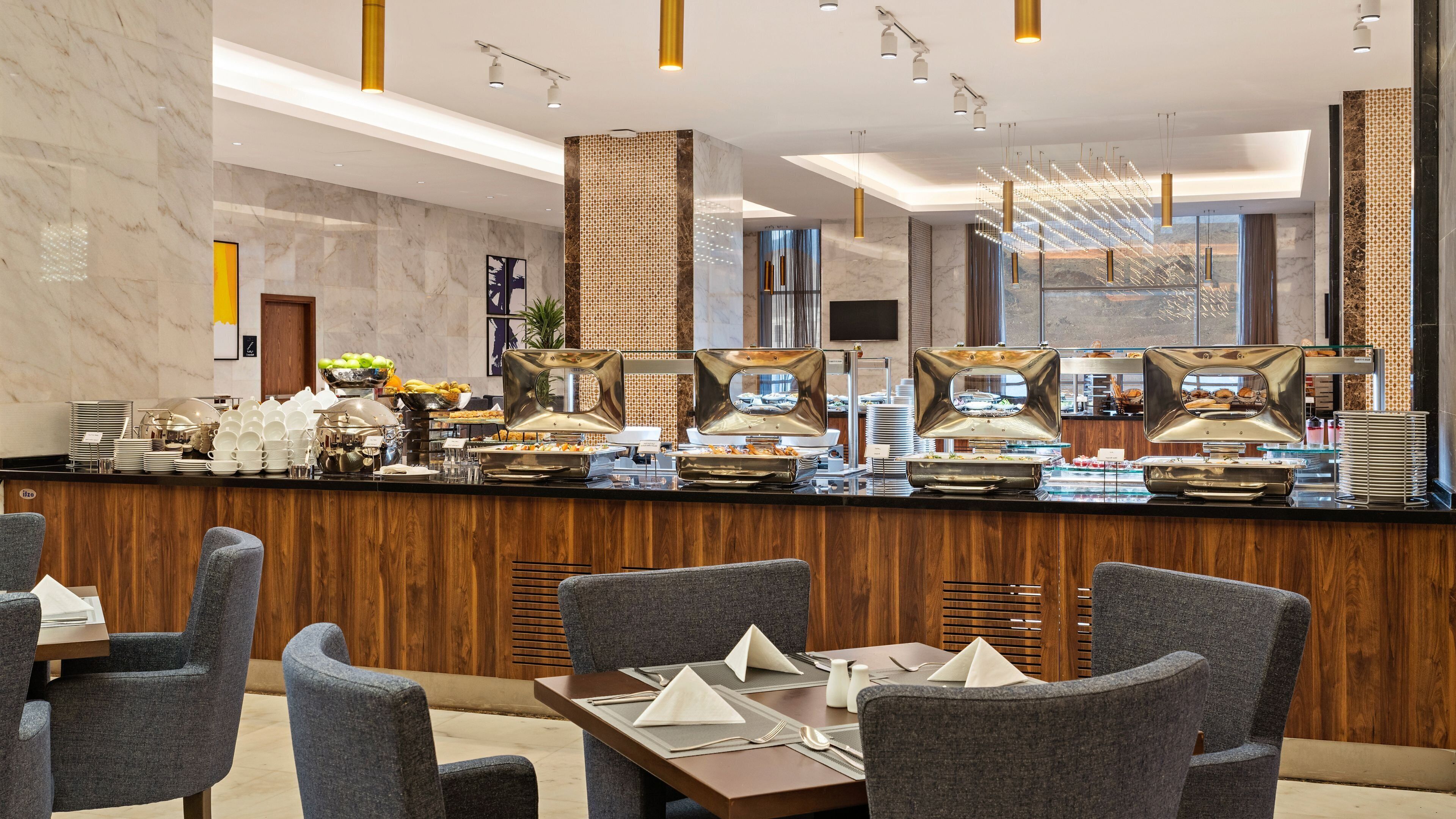A buffet area with a marble counter, various food stations, and seating arrangements.