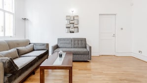 Un salon moderne avec un canapé gris, une table basse en bois et un élément décoratif mural.