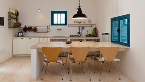 A modern kitchen with a large island, wooden chairs, and a black pendant light. - -La Dimora del Sole- (Cisternino)