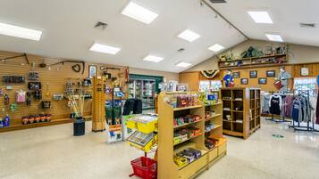 A store interior with wooden shelves, a cash register, and various items on display.